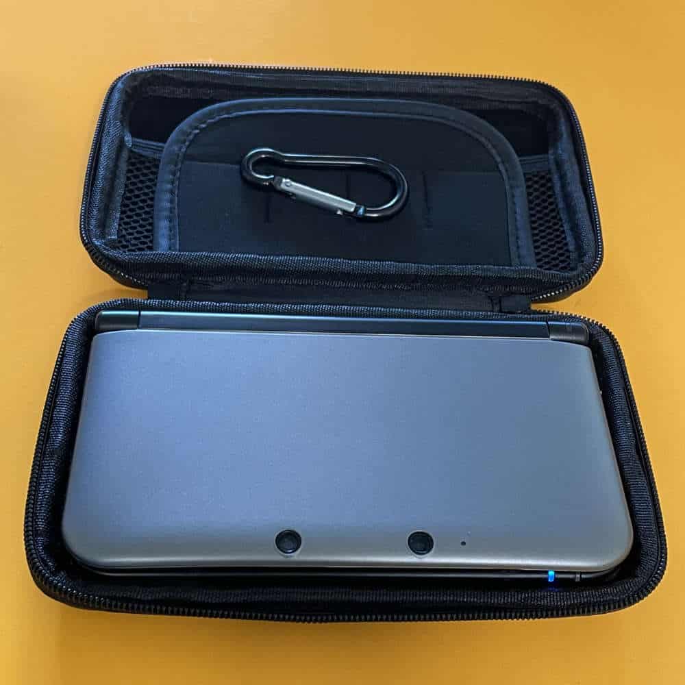 Protective case for 3DS XL with accessories and carabiner clip.