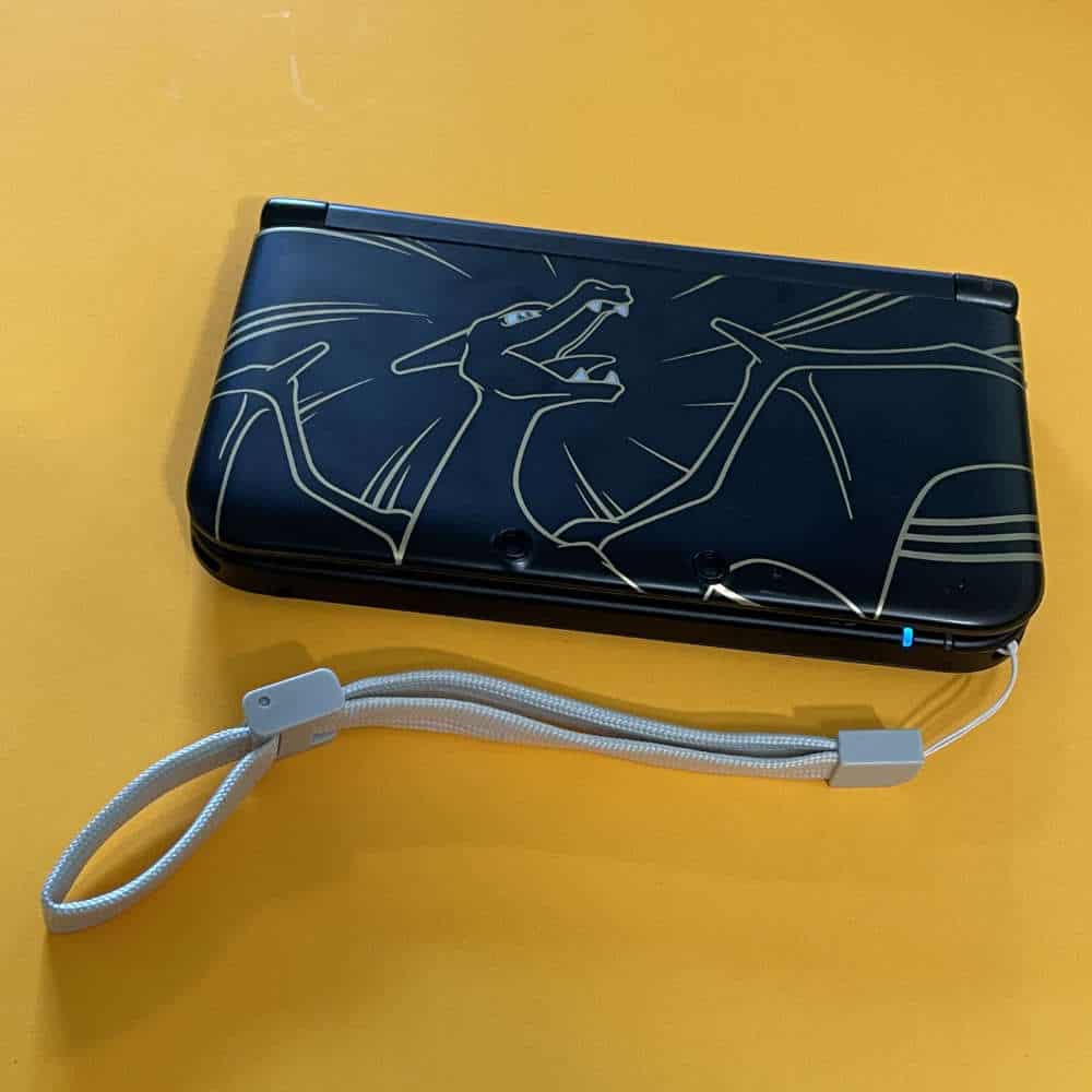 Protective kit for 3DS XL with dragon design and wrist strap.