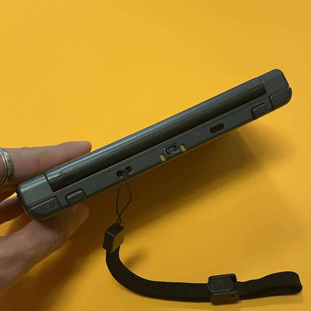 Protective case for New 3DS XL gaming console with wrist strap.