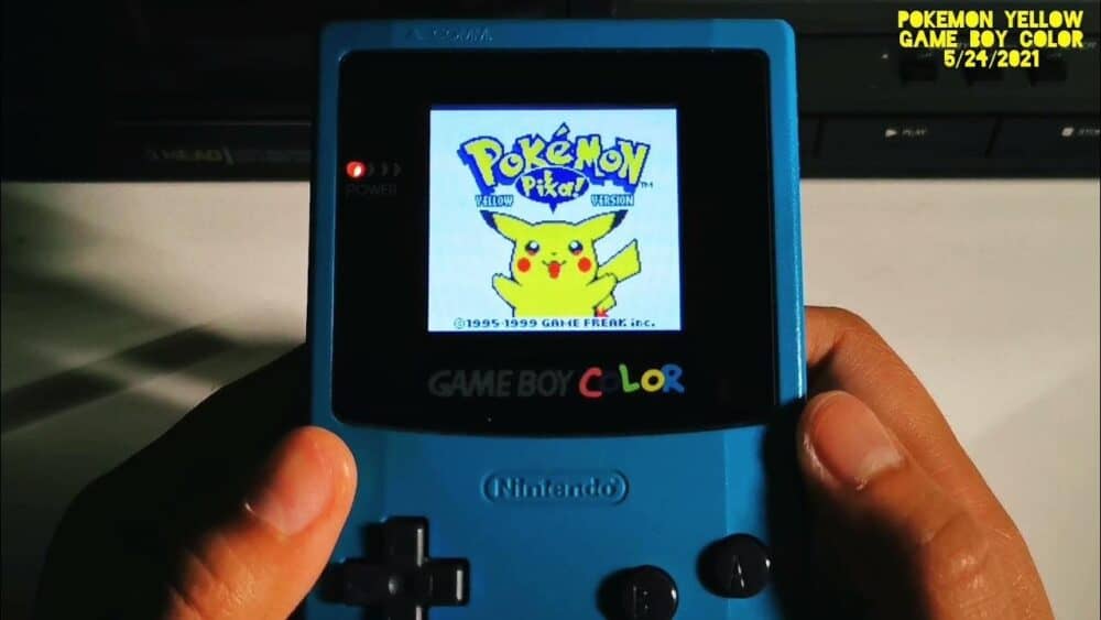 Portable Pokemon Yellow Game Boy Color device with screen displaying Pikachu.