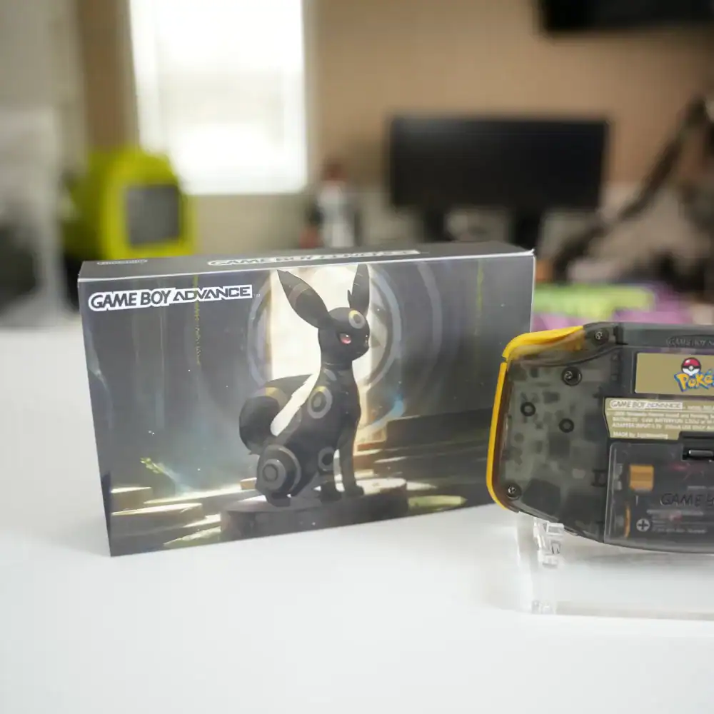 Umbreon-themed Nintendo Game Boy Advance GBA console with box and display stand.