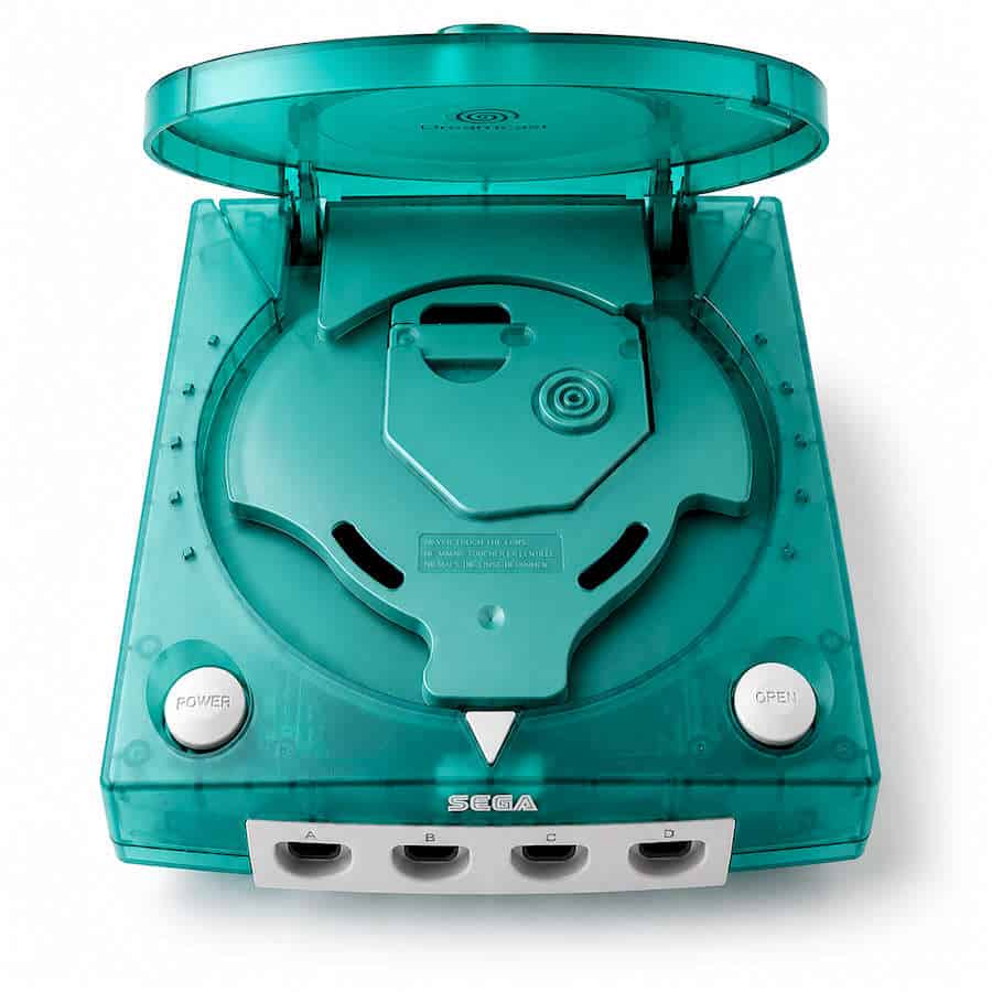 Teal Sega Dreamcast console with open disc tray and transparent casing.