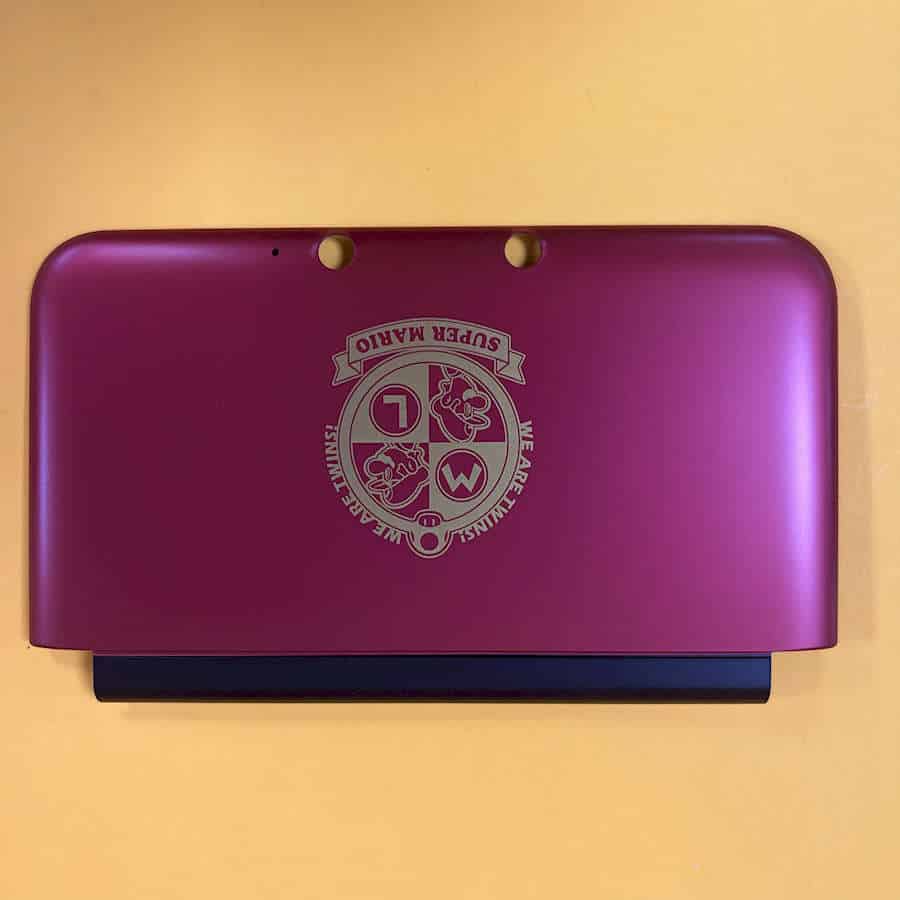 Pink Nintendo 3DS XL shell with Charizard logo on the back.