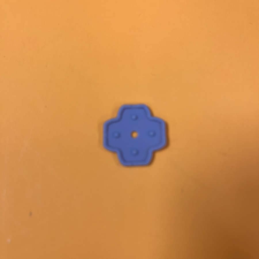 Blue rubber pad for Nintendo 3DS XL D-Pad button on orange background.
