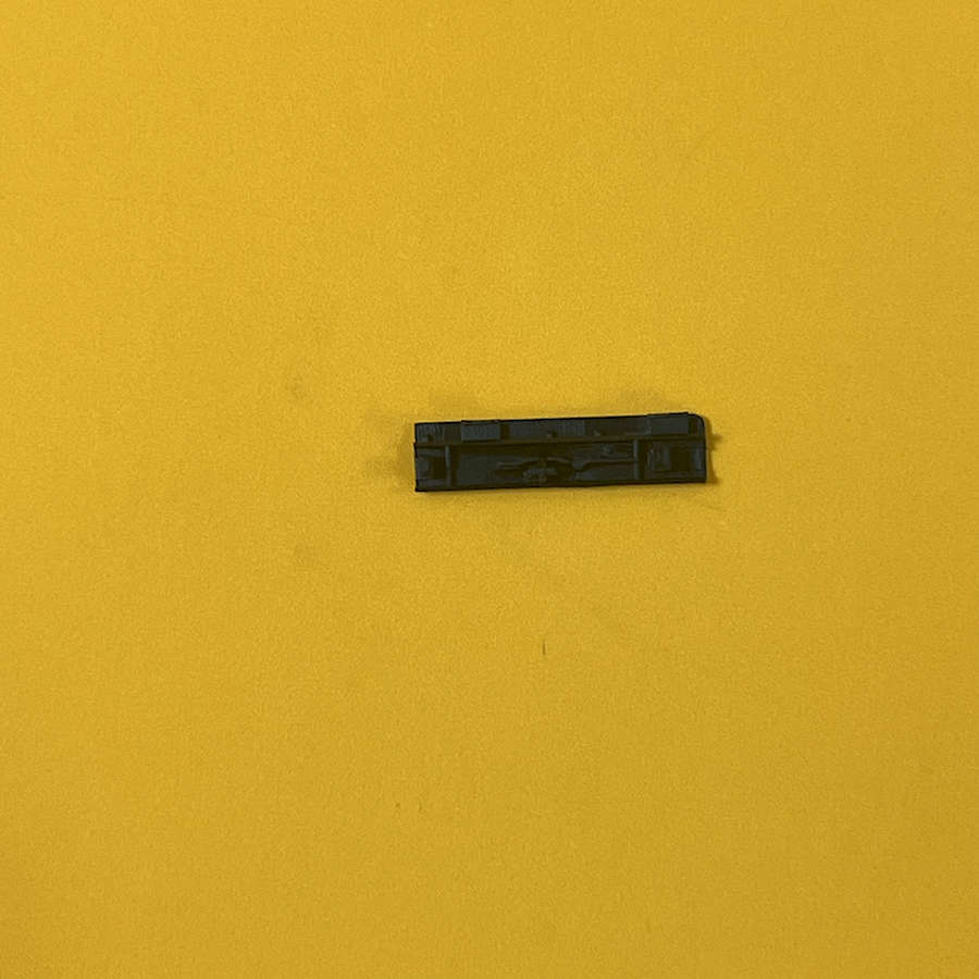Black Nintendo 3DS XL home button replacement part on yellow background.