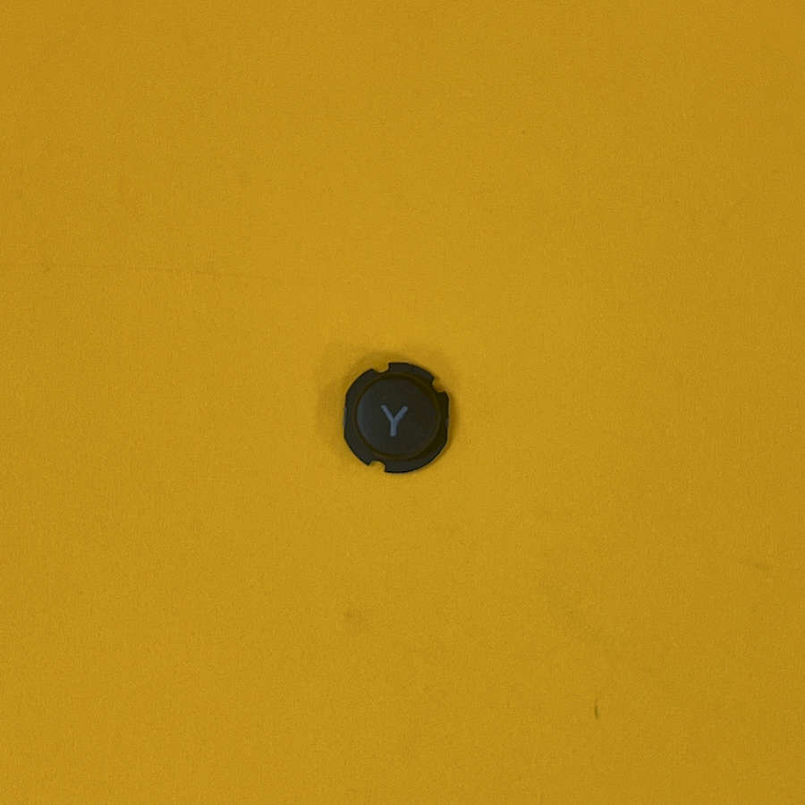 Black Y button for Nintendo 3DS XL on yellow background.