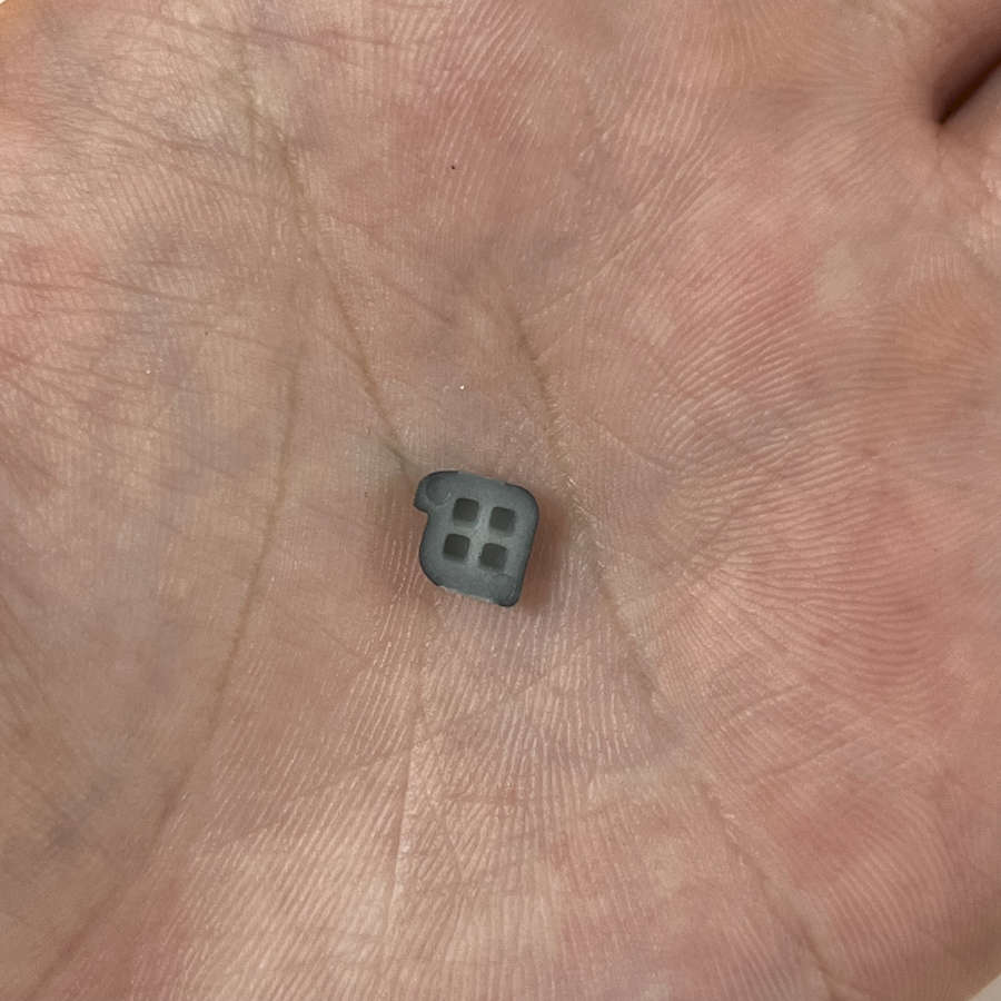 Black Nintendo 3DS power button replacement part on palm.
